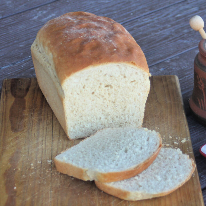 Slices of bread with entire loaf on a cutting board.