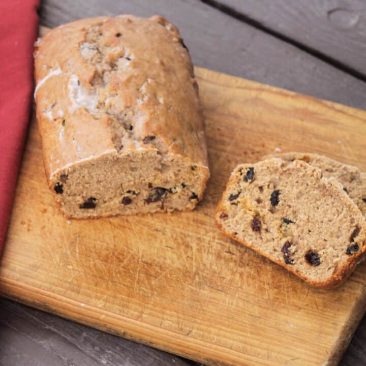 Cinnamon raisin quick bread on a cutting board with slices.