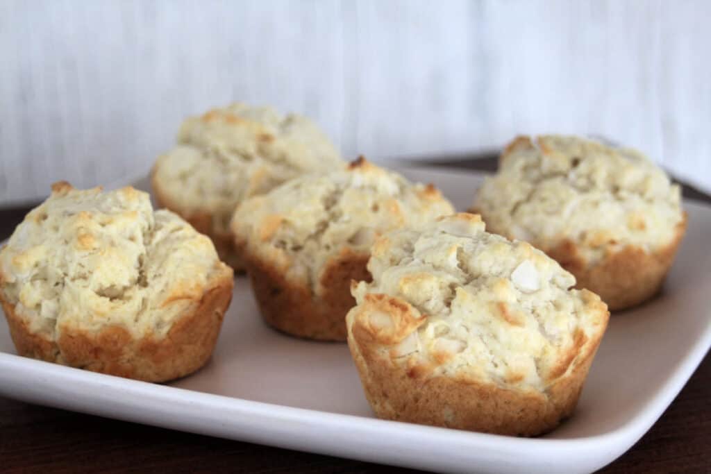 Coconut muffins on a white platter.