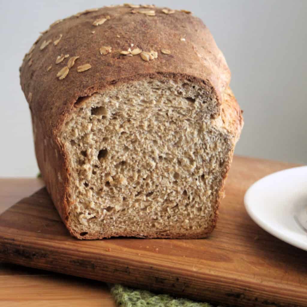 A loaf of oatmeal bread that has end sliced off.