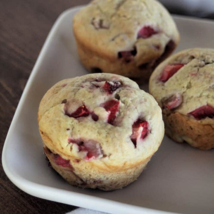 Close up of strawberry muffins on a white plate.
