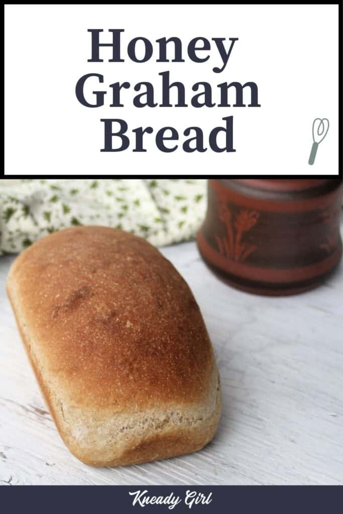 A loaf of honey graham bread on a white table with a towel and clay pot in the background with text overlay.