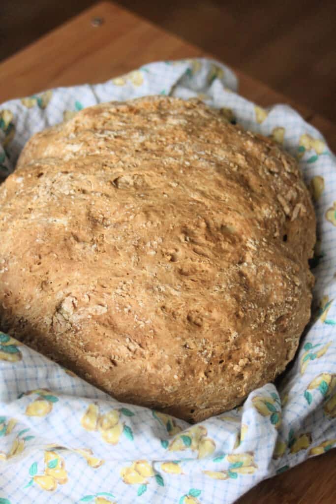 A round loaf of Irish Soda Bread sitting inside a linen lined basket.