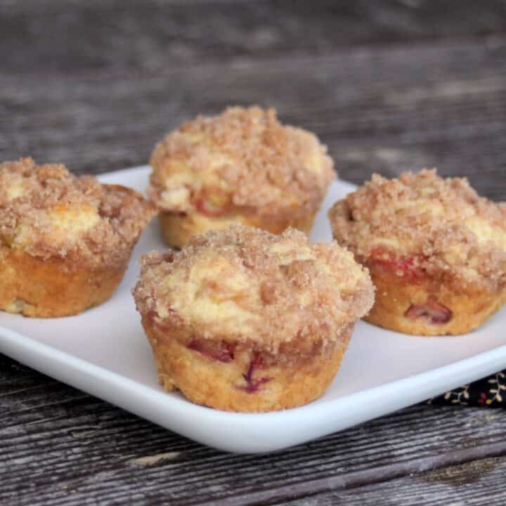 4 rhubarb muffins on a square, white plate.