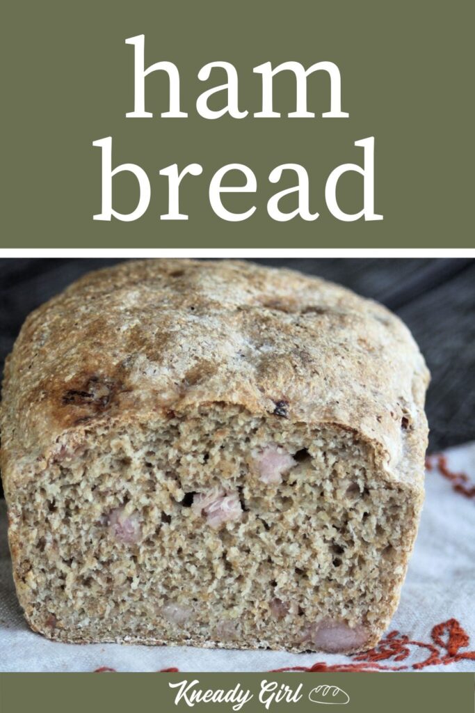 A loaf of ham bread with the end cut off exposing bits of ham inside the bread sitting on an embroidered napkin with text overlay.