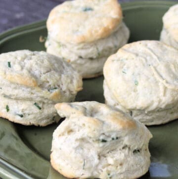 A green plate stacked with chive biscuits.