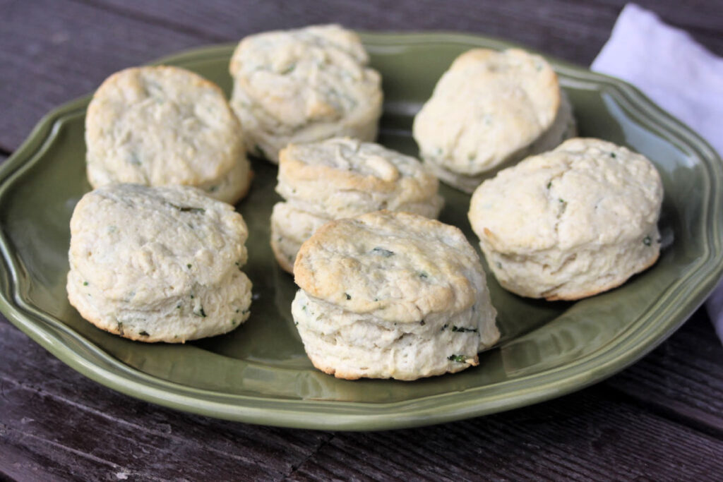 A green plate stacked with chive biscuits.