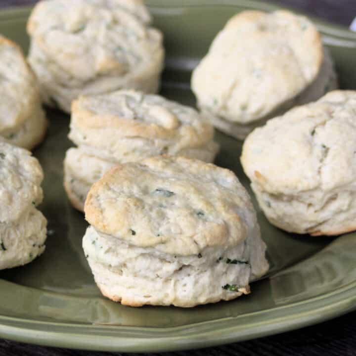 A green plate stacked with chive biscuits.