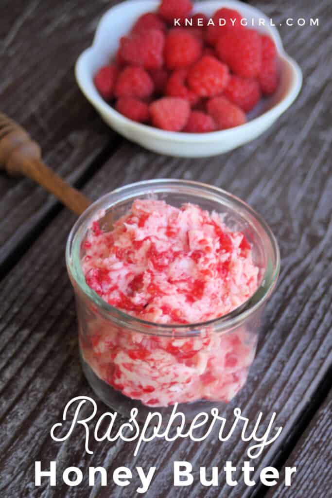 An open jar of raspberry honey butter sitting in front of a white bowl full of fresh raspberries with text overlay.