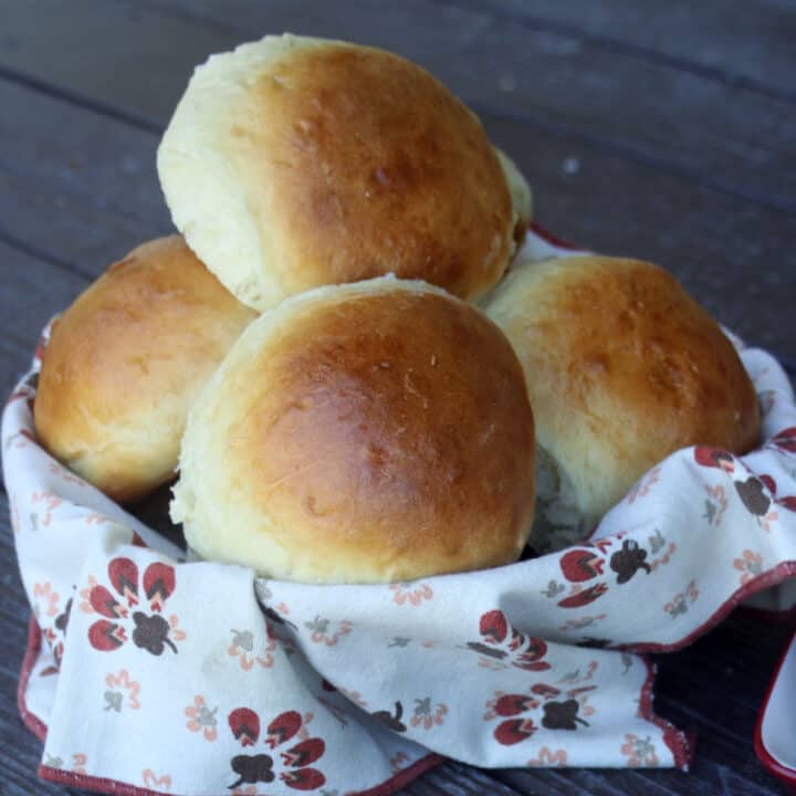 a napkin lined basket overflowing with sweet potato buns.