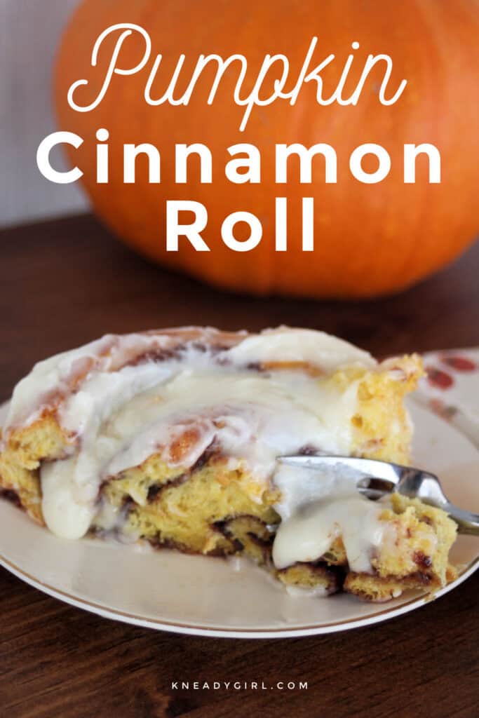 A pumpkin cinnamon roll with cream cheese frosting on a white plat with a fork cutting through the edge, sitting in front of a pumpkin with text overlay.