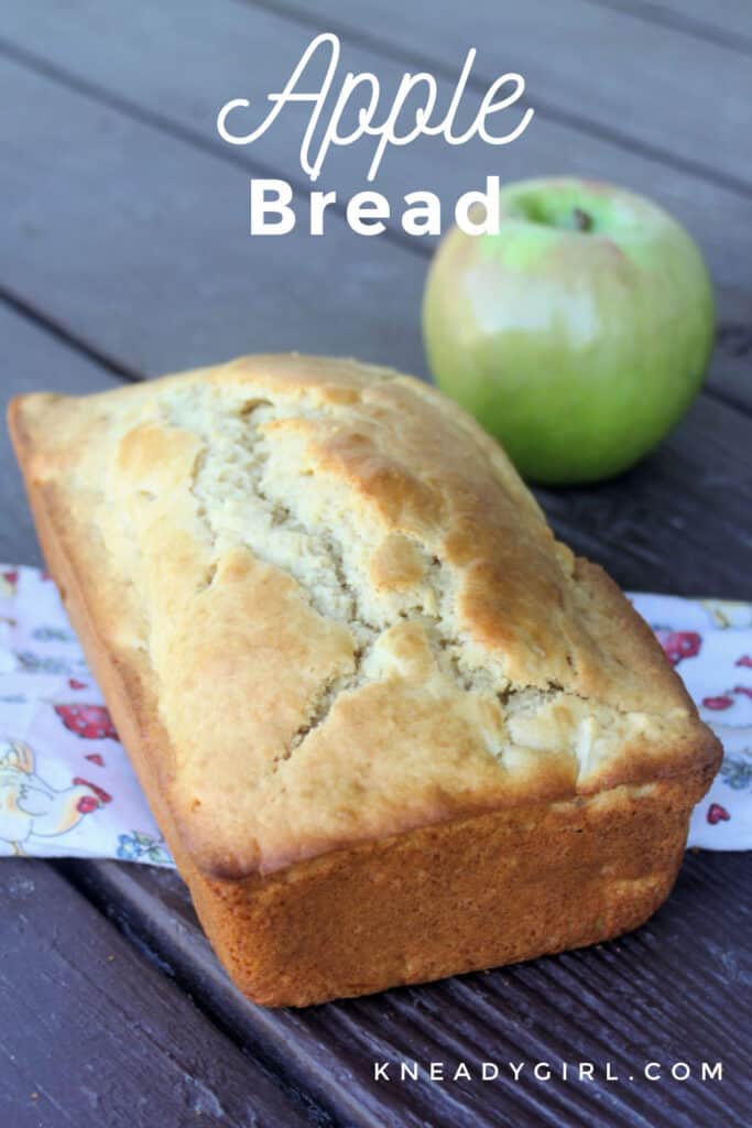 A loaf of apple bread on a linen with green apple in the background and text overlay reading: apple bread.