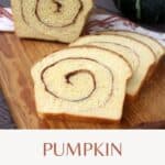 Slices of pumpkin cinnamon swirl bread on a cutting board with remaining loaf behind them and a green pumpkin in the background with text overlay stating: Pumpkin Cinnamon Swirl.