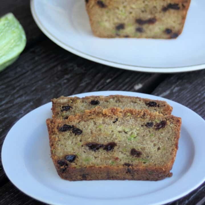 slices of zucchini raisin bread on a white plate.