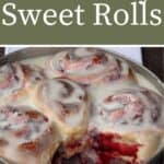 A pan of frosted cranberry sweet rolls with one missing sitting on a white towel with text overlay reading cranberry sweet rolls.