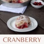 A cranberry sweet roll sitting on a white plate with a napkin sitting underneath a pan full of rolls and a white dish full of fresh cranberries in the background with text overlay reading cranberry sweet rolls.
