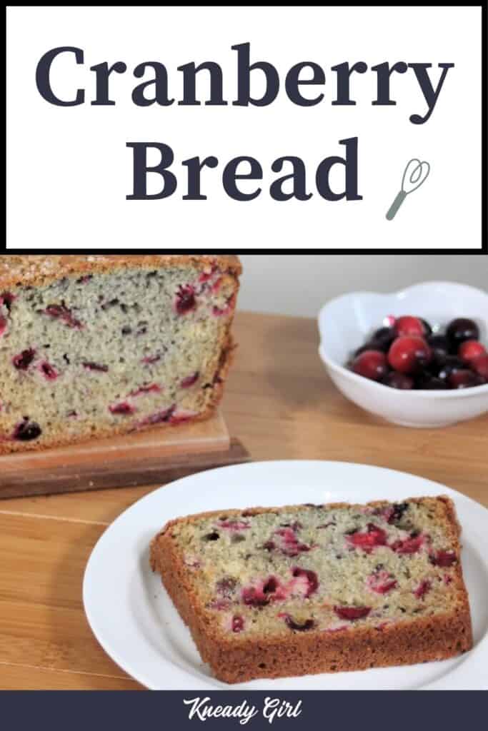 A slice of cranberry bread on a white plate sitting in front of a bowl of cranberries and the remaining loaf with text overlay stating: cranberry bread.