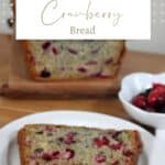 A slice of cranberry bread on a white plate sitting in front of the remaining loaf and a bowl of cranberries with text overlay reading cranberry bread.