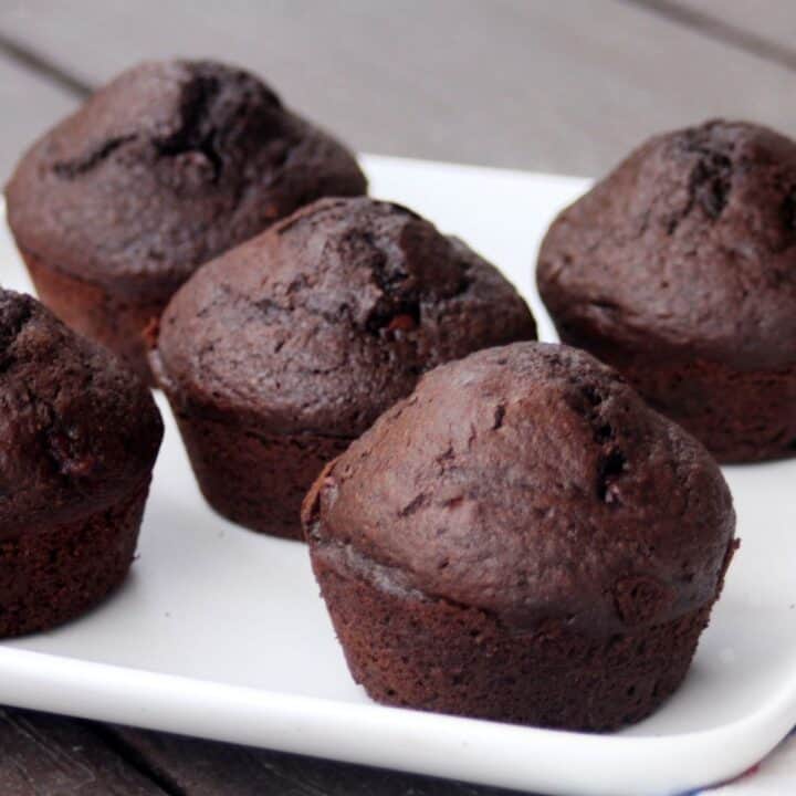 A white plate full of chocolate rye muffins.