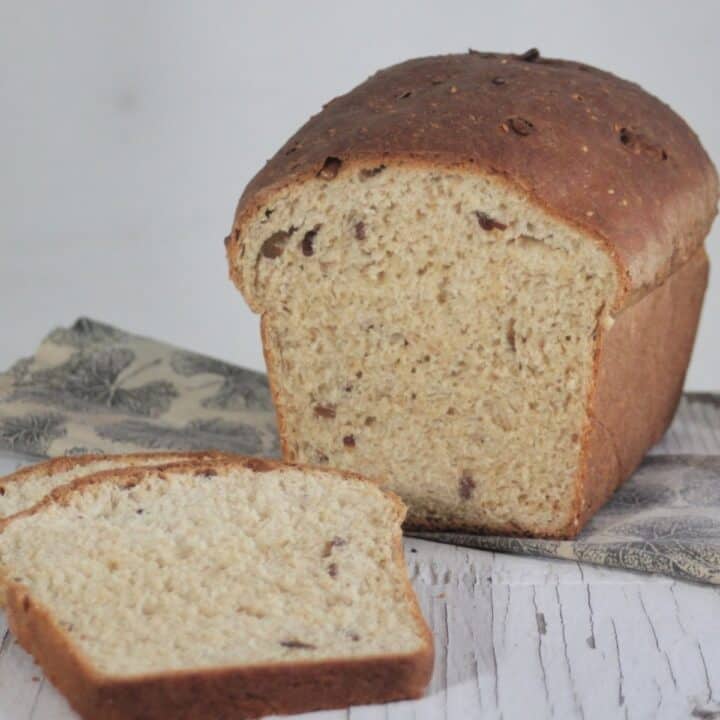 Slices of bread sitting in front of the rest of the loaf resting on a napkin.