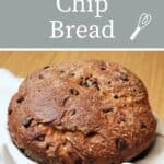 A round loaf of chocolate chip bread in a white linen lined basket with text overlay stating chocolate chip bread.