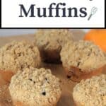 Muffins lined up on a wooden board with text overlay reading: Cranberry Muffins.
