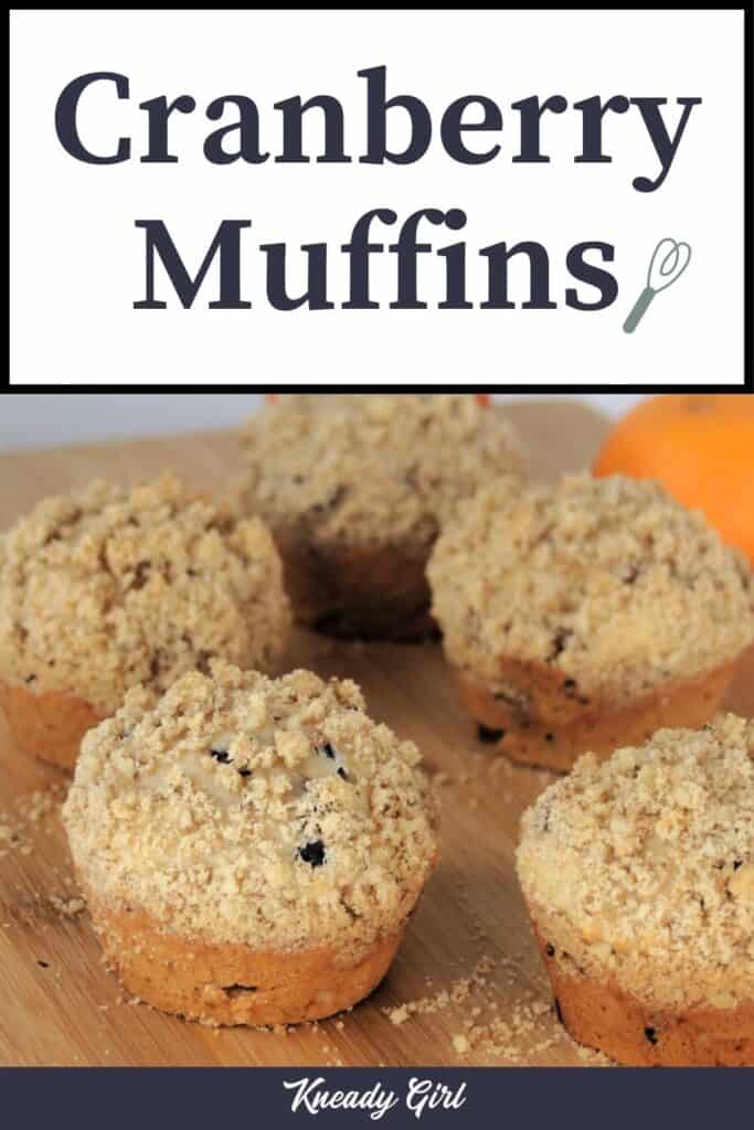 Muffins lined up on a wooden board with text overlay reading: Cranberry Muffins.