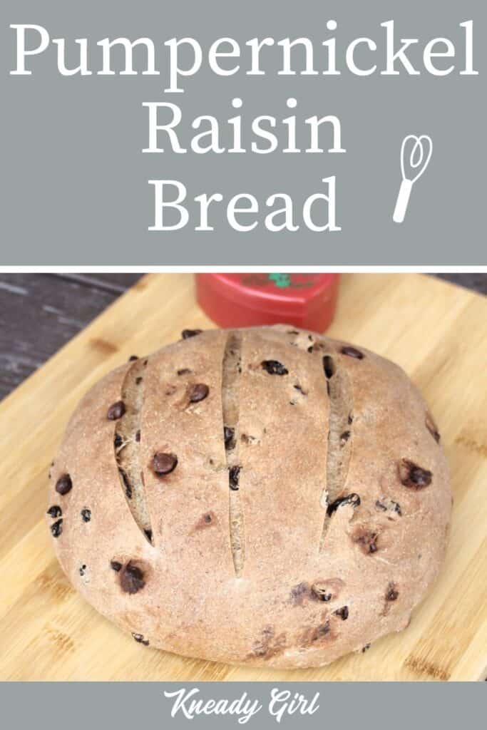 A round loaf of bread on a wooden cutting board with a heart shaped container in the background with text overlay stating: pumpernickel raisin bread.