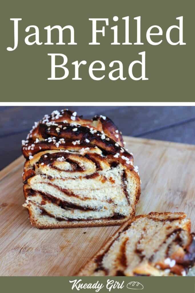 A loaf of jam filled bread sliced open exposing the bread and jam ribbons inside sitting on a wooden cutting board with text overlay stating: jam filled bread.