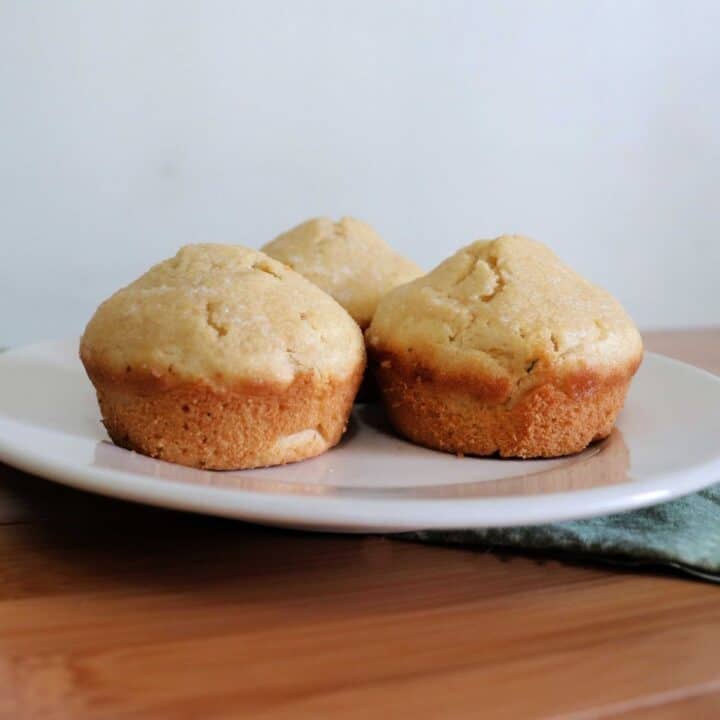 3 butter rum muffins sitting on a white plate.