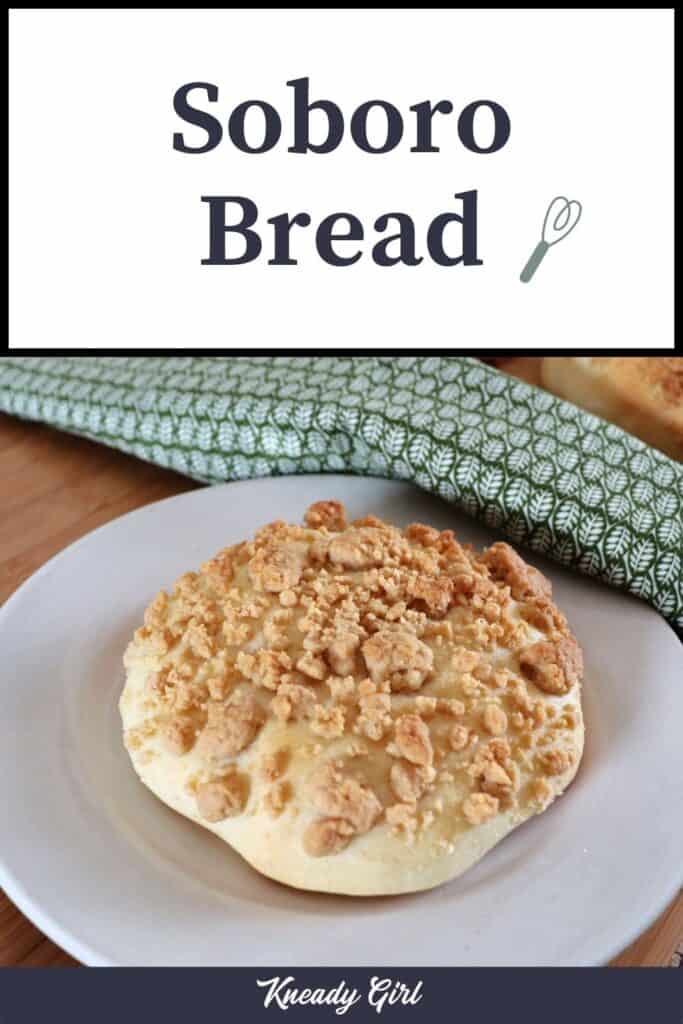 A streusel topped white bread roll sitting on a white plate with a green cloth behind hit with text overlay stating: Soboro bread.