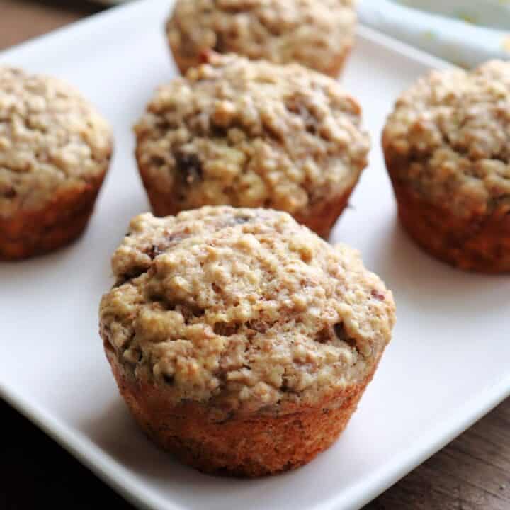 Banana bran muffins sitting on a white plate.