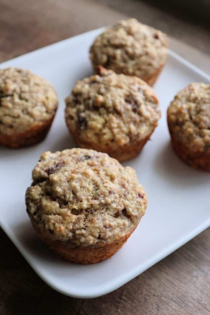 Banana bran muffins sitting on a white plate.