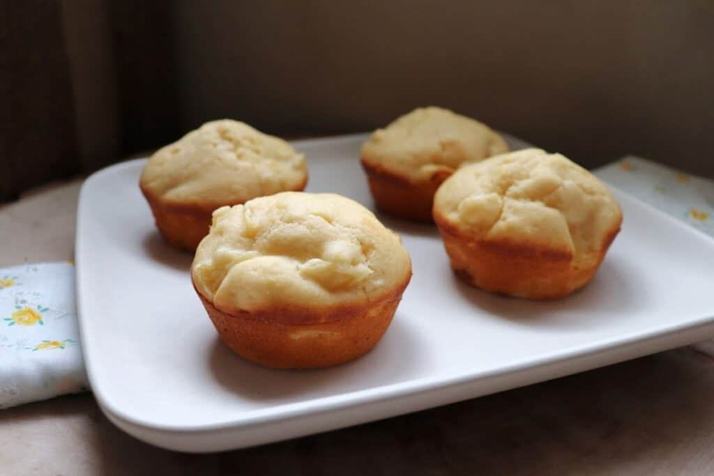 Four Pineapple Muffins on a square white plate.