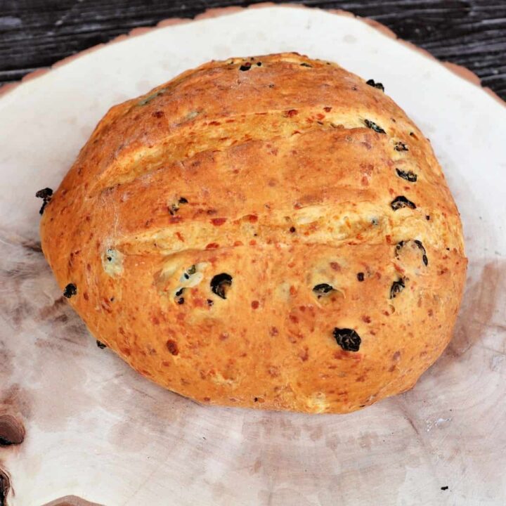 A loaf of cheddar jalapeno bread on a wooden board.