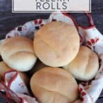A linen lined basket full of stacked rolls as seen from above with text overlay stating: homemade telera rolls.