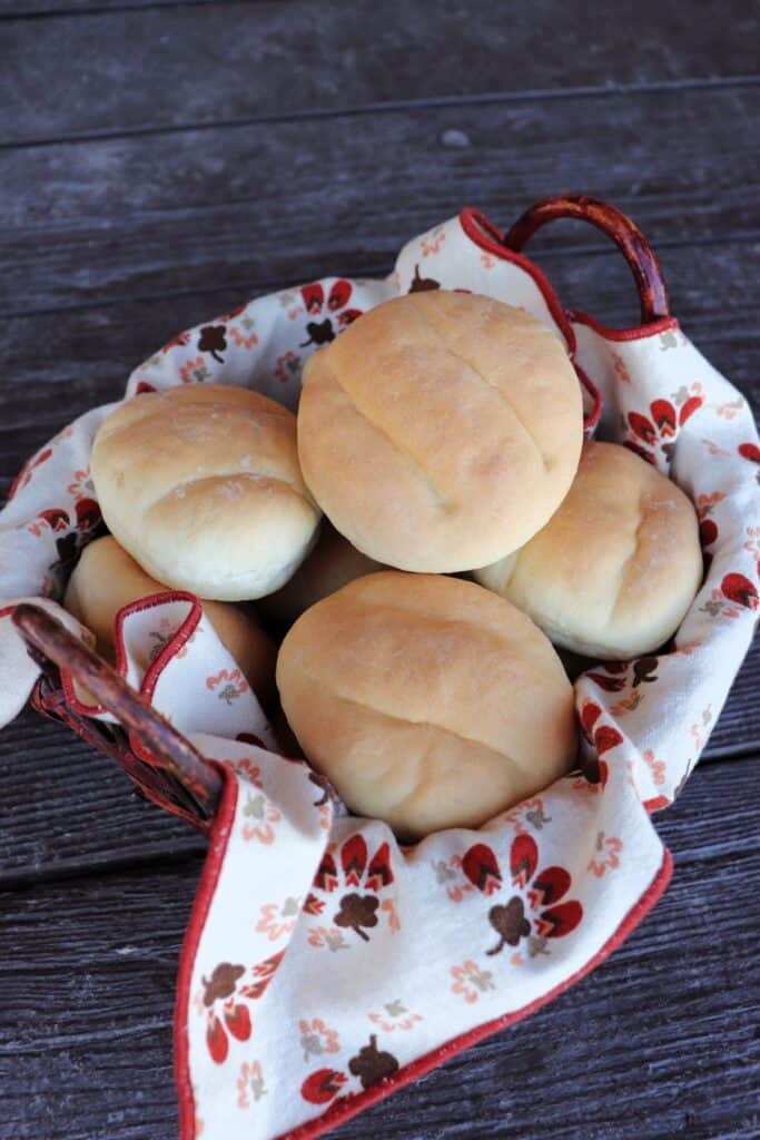 A linen-lined basket of stacked telera rolls.