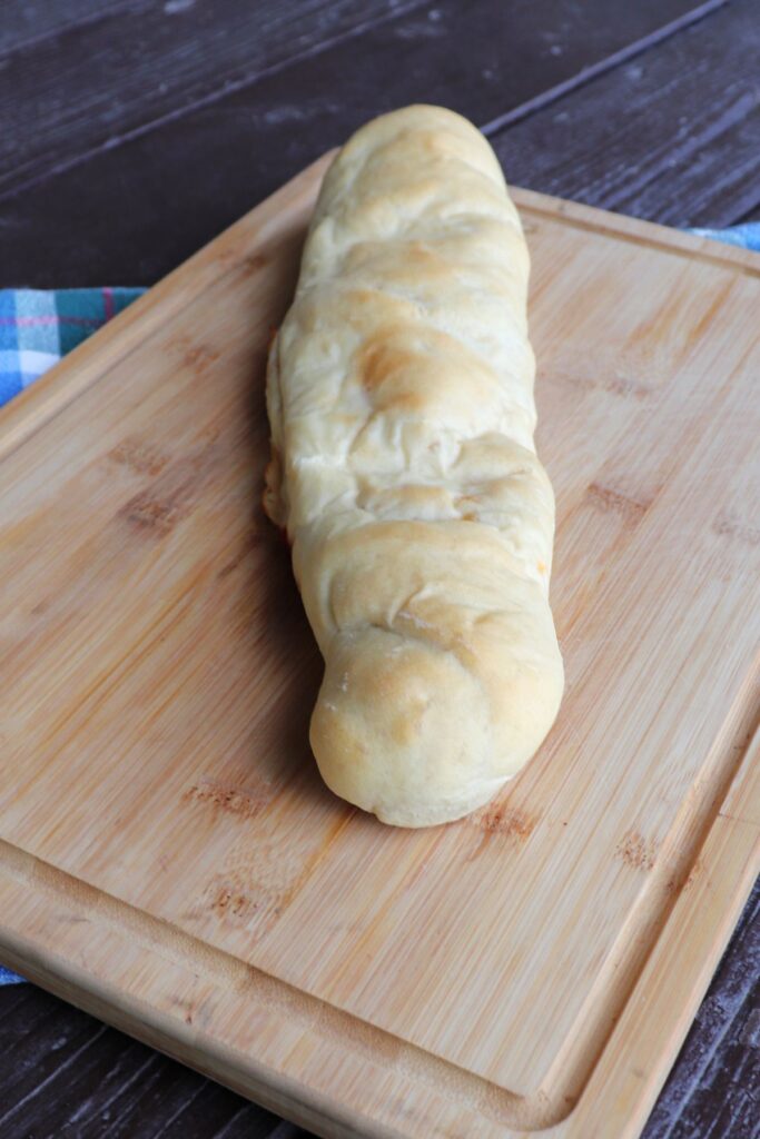 An entire loaf of pepperoni bread on a cutting board.