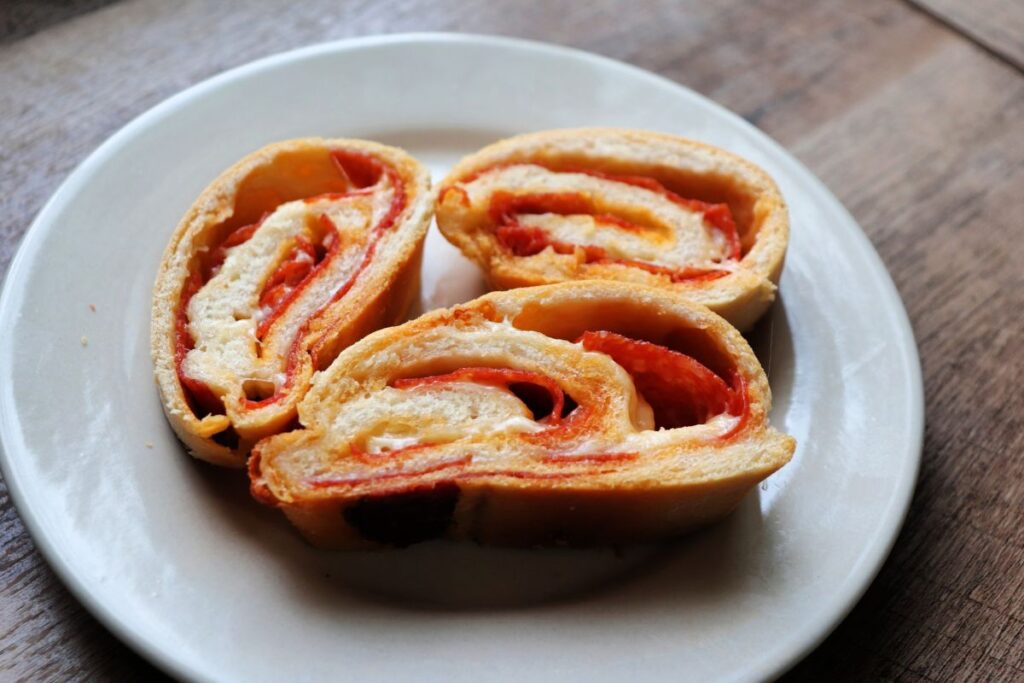 3 slices of pepperoni bread on a white plate.