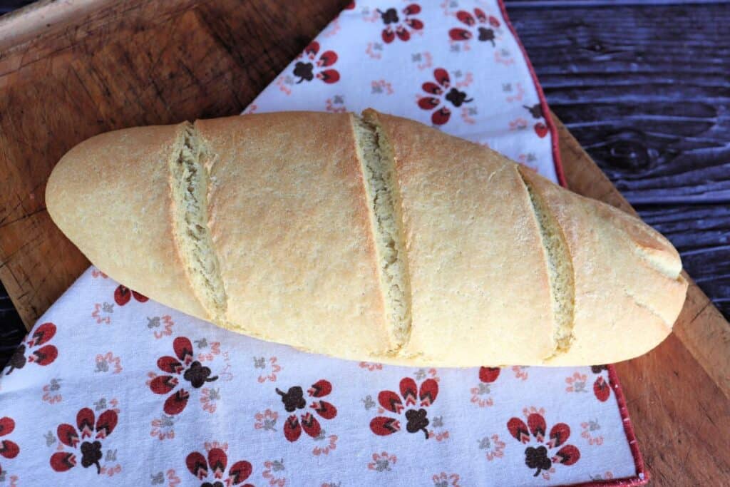 A loaf of semolina bread sitting on a cloth as seen from above.