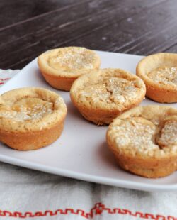 Sesame seed topped mochi muffins sitting on a plate.