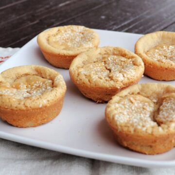 Sesame seed topped mochi muffins sitting on a plate.