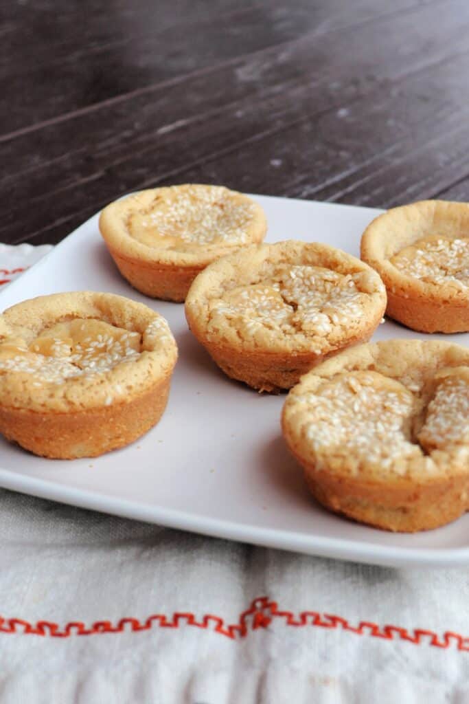 Sesame seed topped mochi muffins on a plate.