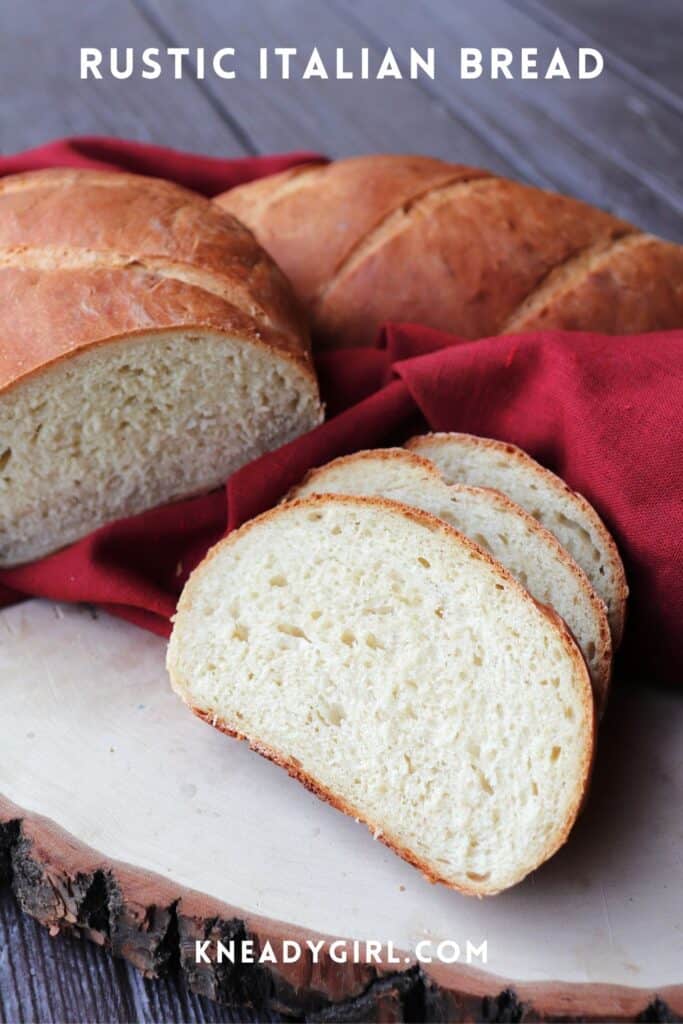 Slices of white bread sit on a board with remaining loaf and red cloth in the background. Text overlay reads: Rustic Italian Bread.