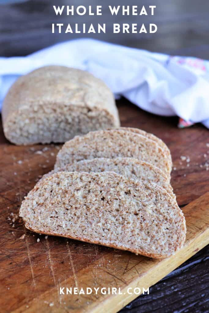 Slices of bread on a cutting board with remaining loaf surrounded by a white cloth in the background. Text overlay reads: Whole Wheat Italian Bread.