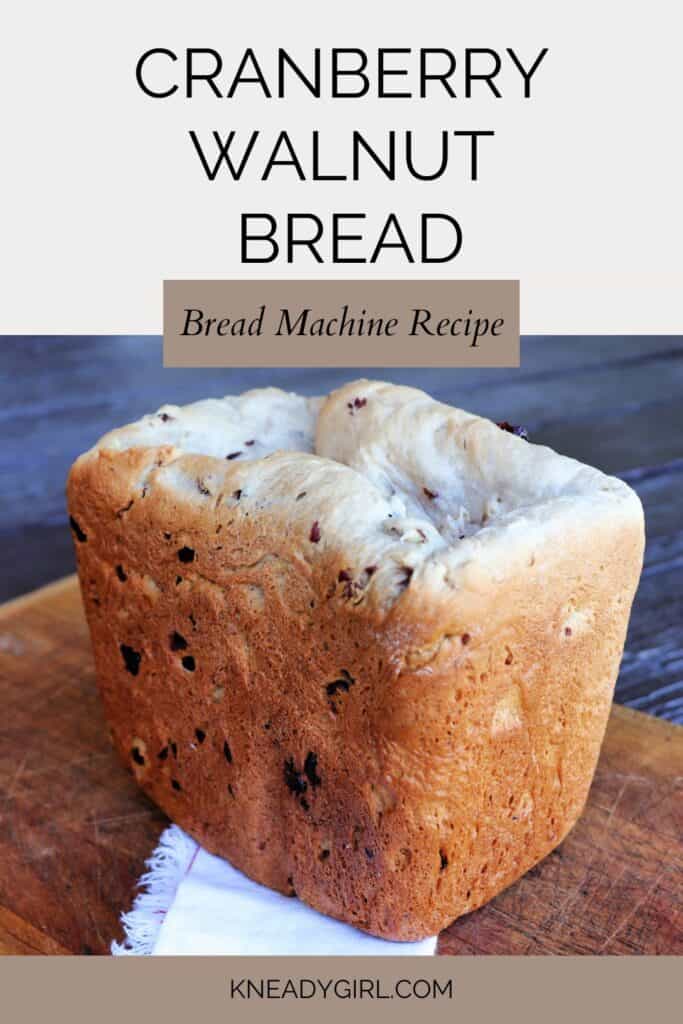 A loaf of bread sits on a board. Text overlay reads: Cranberry Walnut Bread - Bread Machine Recipe.