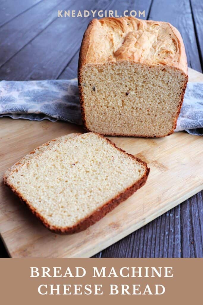 A slice of bread sits on a board with the remaining sitting on a cloth behind it. Text overlay reads: Bread Machine Cheese Bread.