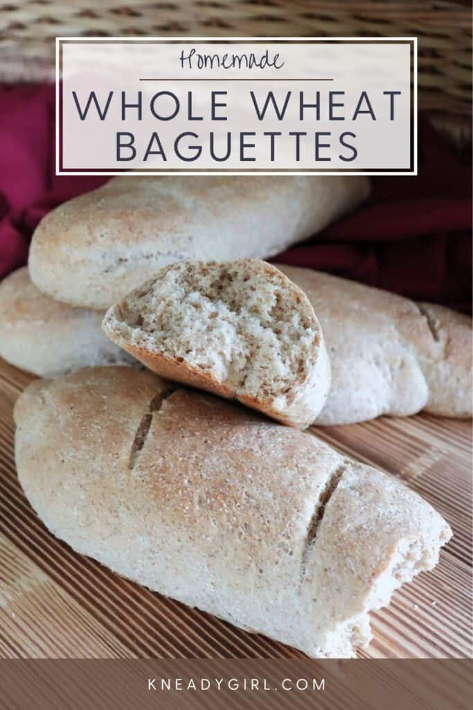 The end of a loaf of bread that has been torn exposing the inside sits on top of more loaves of bread. Text overlay reads: Homemade Whole Wheat Baguettes.