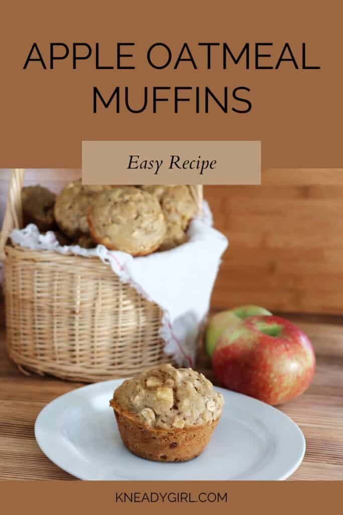 A muffin sits on a plate with white cloth lined basket full of more muffins and fresh apples in the background. Text overaly reads: Apple Oatmeal Muffins - Easy Recipe.