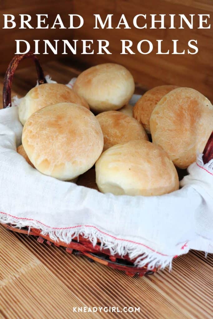 A basket lined with a white cloth is full of bread rolls. Text overlay reads: Bread Machine Dinner Rolls. 